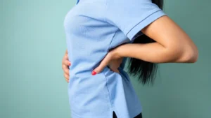 Mujer sujetándose la zona lumbar debido a una lesión de espalda.